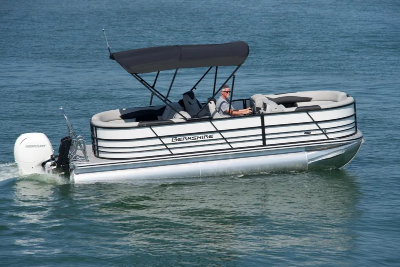 The Image of 2026 Berkshire 22 RFX LE pontoon boat cruising on a calm lake. - 0