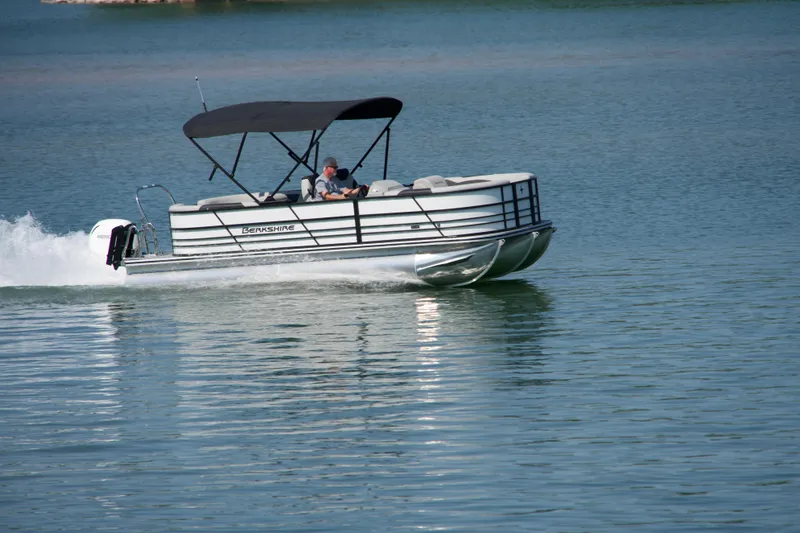 Slide: The Image of 2026 Berkshire 22 RFX LE pontoon boat cruising on a serene lake. - 26
