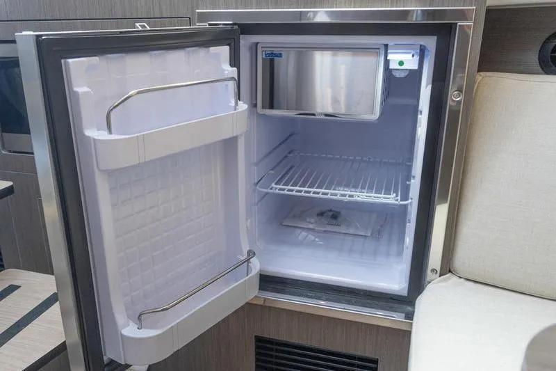 Slide: The Image of Open refrigerator inside 2026 Beneteau Gran Turismo 35 yacht, showcasing interior storage space. - 23