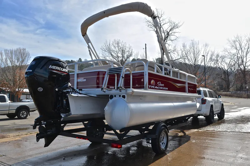 Slide: The Image of 2023 Sun Tracker Party Barge 18 DLX pontoon boat on trailer, parked outdoors. - 14