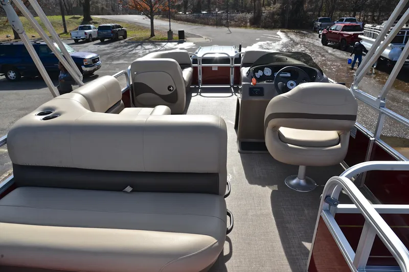 Slide: The Image of 2023 Sun Tracker Party Barge 18 DLX interior with beige seating and steering console. - 18