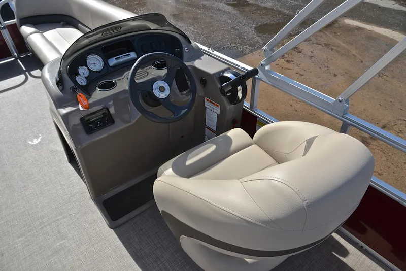 Slide: The Image of 2023 Sun Tracker Party Barge 18 DLX helm with beige captain's chair and control panel. - 24