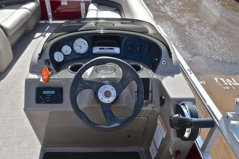 Slide: The Image of 2023 Sun Tracker Party Barge 18 DLX dashboard with steering wheel and gauges. - 25