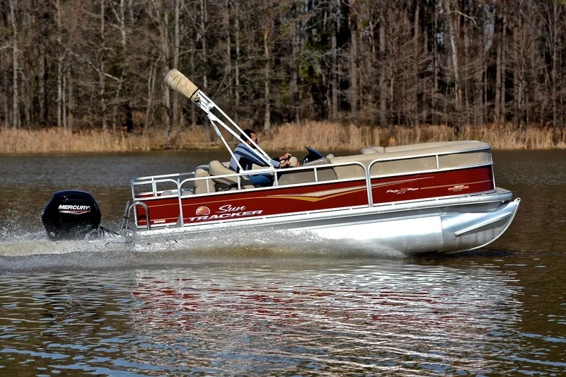 Slide: The Image of 2023 Sun Tracker Party Barge 18 DLX cruising on a lake with trees in the background. - 3