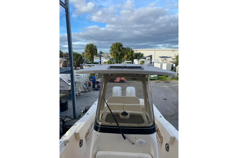 Slide: The Image of 2024 Grady-White Fisherman 257 boat docked, showcasing helm and seating area under cloudy sky. - 6