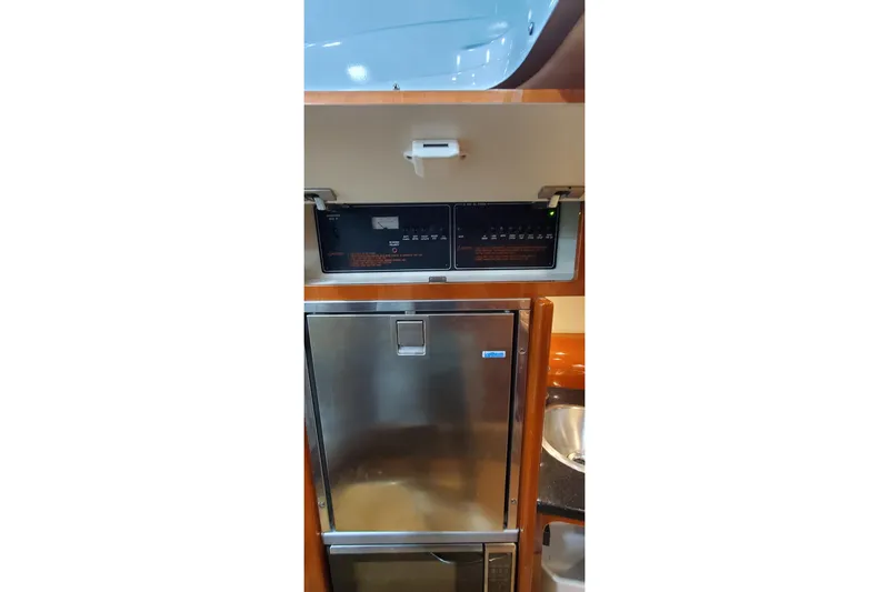 Slide: The Image of Open refrigerator inside 2011 Formula 310 FX5 Bowrider boat, showcasing storage space. - 26