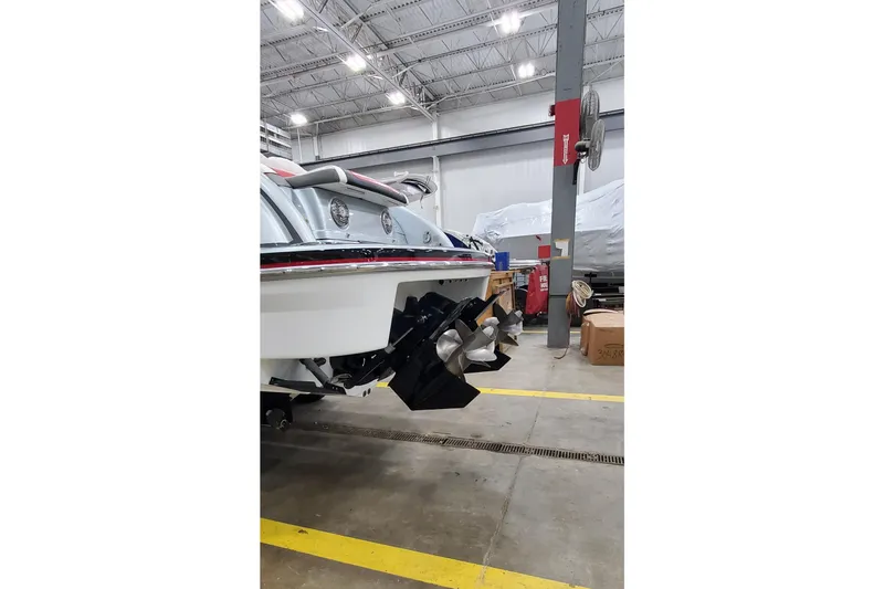 Slide: The Image of 2011 Formula 310 FX5 Bowrider boat interior with red and white seating in a warehouse. - 4