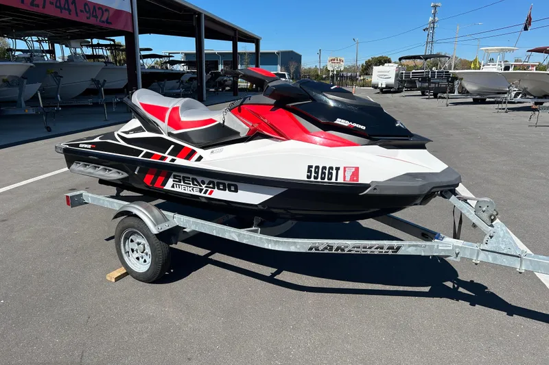 Slide: The Image of 2012 Sea-Doo Wake 155 jet ski on a Karavan trailer in a boat dealership lot. - 1