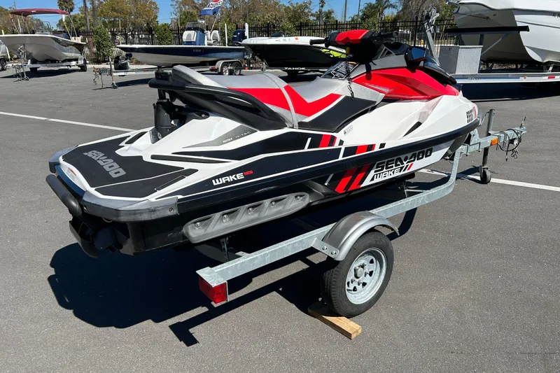 Slide: The Image of 2012 Sea-Doo Wake 155 jet ski on trailer in parking lot. - 2