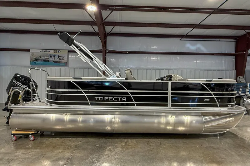 Slide: The Image of 2025 Trifecta 22RF LE pontoon boat in showroom, featuring sleek design and Suzuki engine. - 1