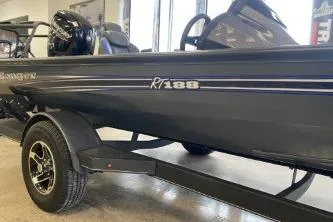 Slide: The Image of 2023 Ranger RT188 boat, sleek black design, displayed indoors on a trailer. - 1