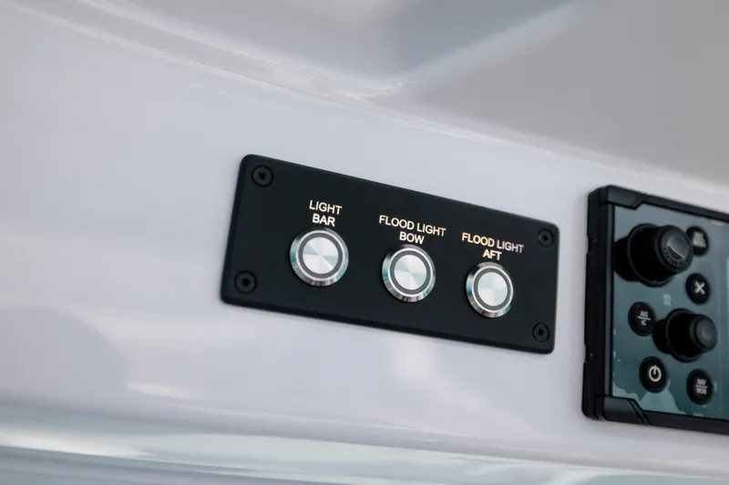 Slide: The Image of Control panel of 2026 Axopar 29 CCX with light and floodlight switches. - 17