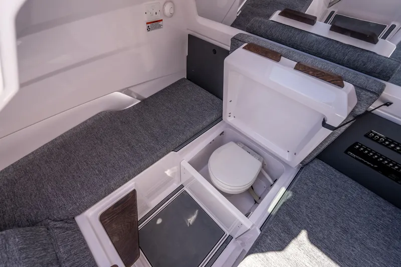 Slide: The Image of 2026 Axopar 29 CCX boat interior with hidden toilet compartment and gray seating. - 21
