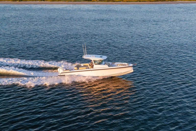 The Image of 2026 Axopar 29 CCX cruising on open water at sunset. - 0