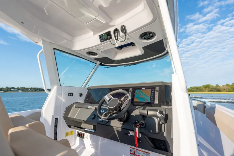 Slide: The Image of 2026 Axopar 29 CCX boat cockpit with modern navigation system and steering wheel. - 13
