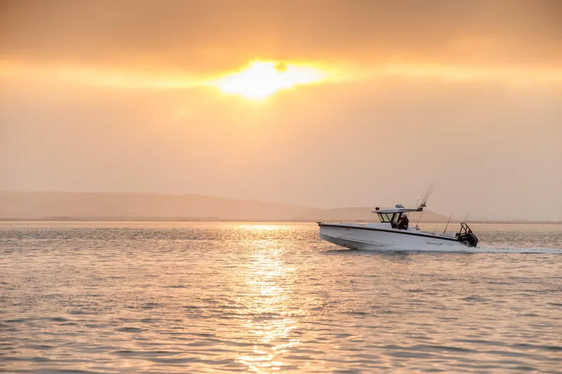 Slide: The Image of 2026 Axopar 29 CCX boat cruising at sunset on calm waters. - 3