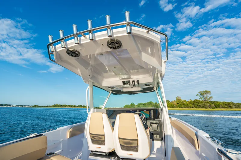 Slide: The Image of 2026 Axopar 29 CCX boat cruising on a sunny day with clear blue skies. - 14
