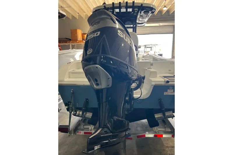 Slide: The Image of 2025 Sea Pro 242 Center Console boat with Suzuki 350 outboard engine in a garage. - 2