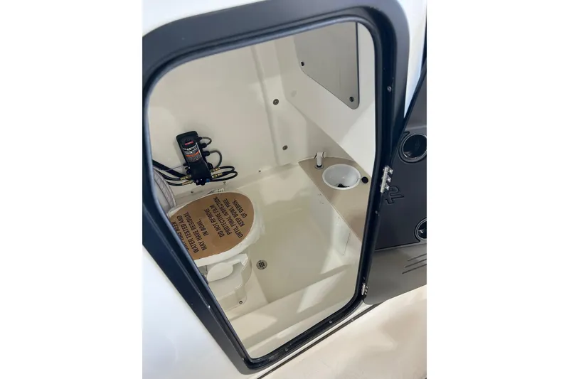 Slide: The Image of 2025 Sea Pro 242 Center Console boat interior with compact restroom and sink. - 6
