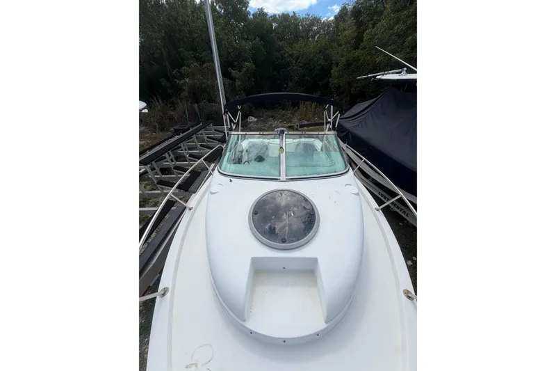Slide: The Image of 2002 Seaswirl 2101 boat with windshield and hatch, docked near trees. - 11