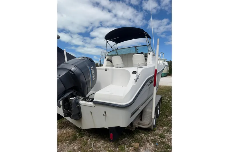 Slide: The Image of 2002 Seaswirl 2101 boat with Yamaha engine, parked on trailer under blue sky. - 4