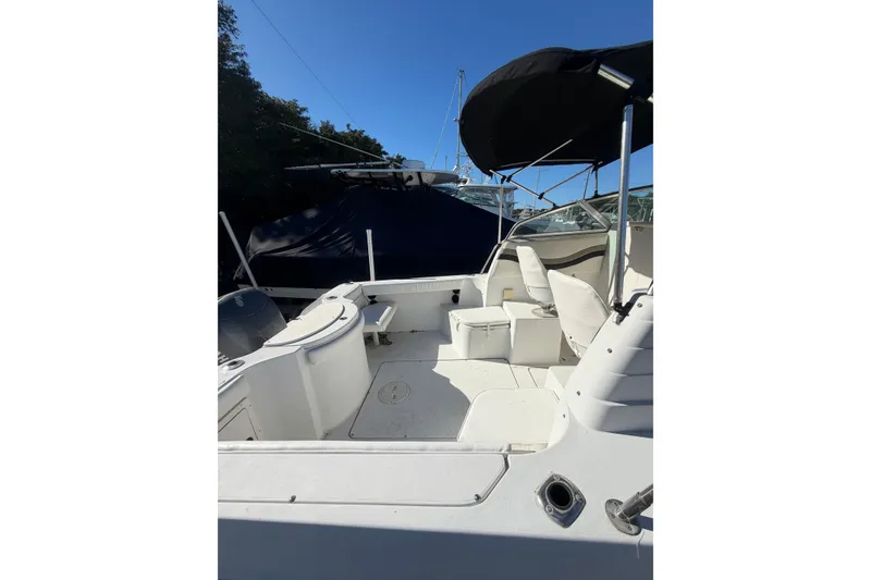 Slide: The Image of 2002 Seaswirl 2101 boat interior with seating and canopy under clear blue sky. - 12