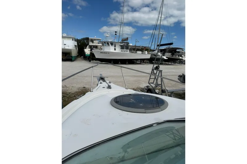 Slide: The Image of 2002 Seaswirl 2101 boat on land, surrounded by other vessels under a blue sky. - 15