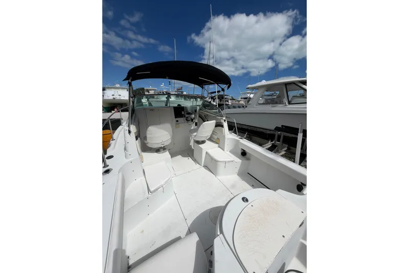 Slide: The Image of 2002 Seaswirl 2101 boat interior with seating, under a clear blue sky. - 5