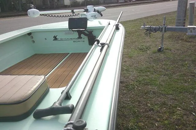 Slide: The Image of 2020 Skimmer Skiff 14 Skiff boat with trolling motor and trailer on grass. - 12