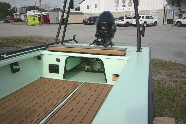 Slide: The Image of 2020 Skimmer Skiff 14 SKIFF boat with outboard motor and wooden deck in a parking area. - 7