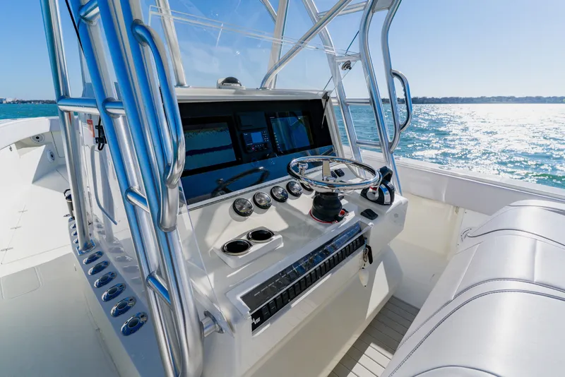 Slide: The Image of 2012 SeaVee 390B boat console with steering wheel and navigation equipment on open water. - 27