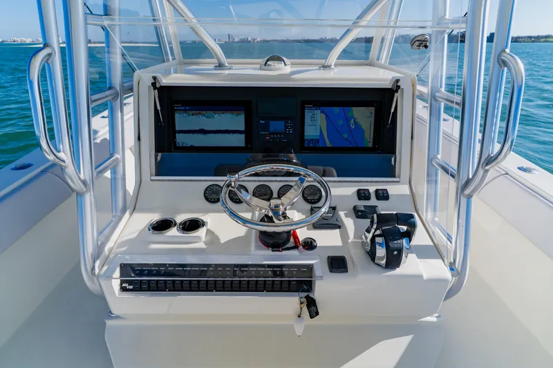 Slide: The Image of 2012 SeaVee 390B boat dashboard with navigation screens and steering wheel on open water. - 28