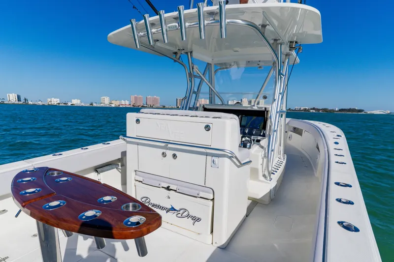 Slide: The Image of 2012 SeaVee 390B boat on water, featuring fishing rod holders and city skyline. - 31