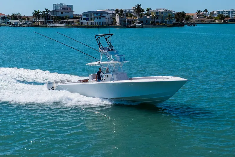 Slide: The Image of 2012 SeaVee 390B boat cruising on clear blue water near coastal homes. - 5