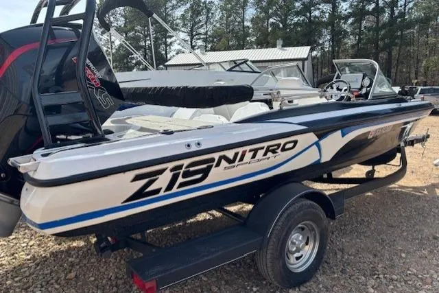 Slide: The Image of 2022 Nitro Z19 Sport boat on trailer, parked outdoors with trees in background. - 4