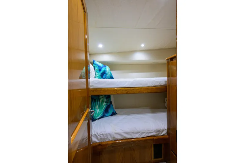 Slide: The Image of Bunk beds in 2015 Viking 62 Convertible yacht cabin with wooden finish and colorful pillows. - 27