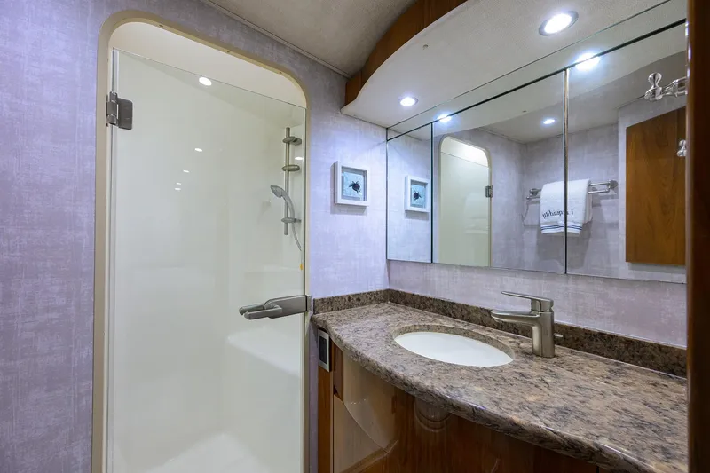 Slide: The Image of Luxurious bathroom in 2015 Viking 62 Convertible yacht with granite countertop and shower. - 48