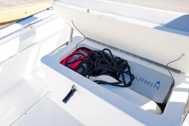 Slide: The Image of Open storage compartment on 2018 Boston Whaler 170 Montauk with rope and Garmin equipment. - 14