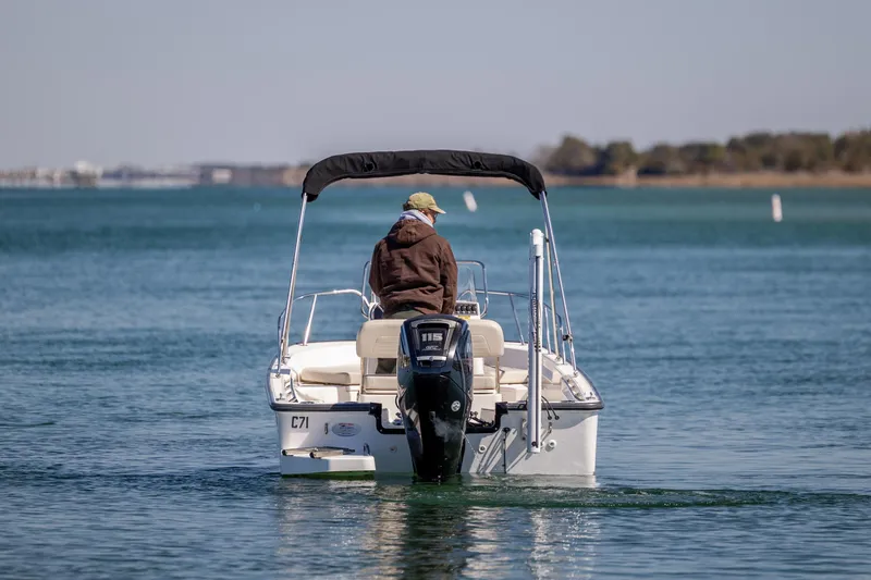 Slide: The Image of 2018 Boston Whaler 170 Montauk boat on calm water, rear view with canopy. - 7