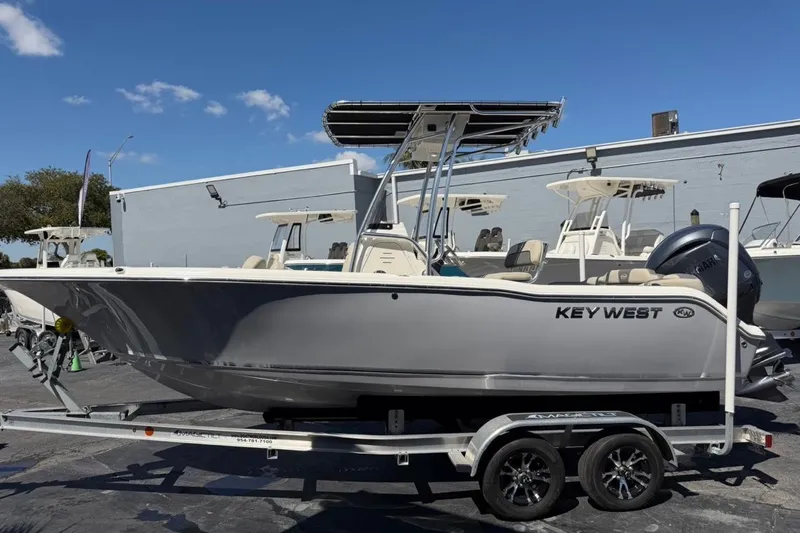 Slide: The Image of 2026 Key West 203 FS boat on trailer, parked outdoors under clear blue sky. - 1