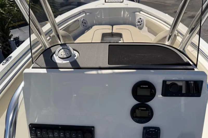 Slide: The Image of 2026 Key West 203 FS boat dashboard with compass, Yamaha controls, and seating area. - 32