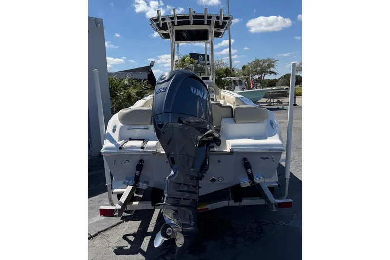 Slide: The Image of 2026 Key West 203 FS boat with Yamaha outboard motor, parked outdoors under blue sky. - 7