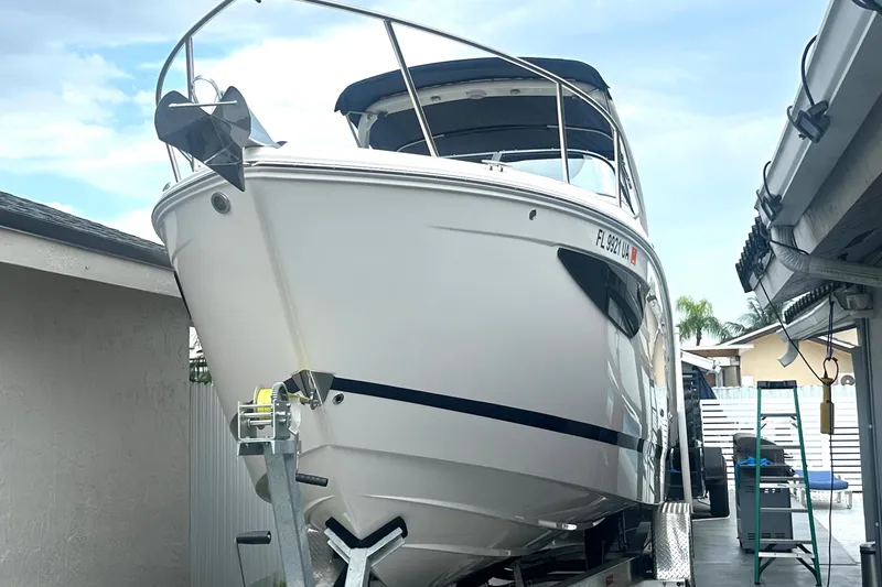 Slide: The Image of 2025 Regal 26 XO boat on trailer, parked in residential driveway. - 1