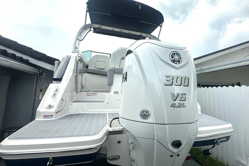 Slide: The Image of 2025 Regal 26 XO boat with Yamaha 300 V6 engine, docked near a white fence. - 14