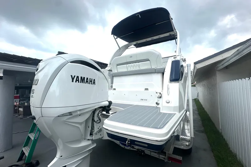 Slide: The Image of 2025 Regal 26 XO boat with Yamaha engine, docked outdoors under cloudy sky. - 15