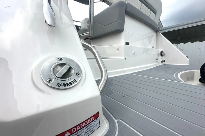 Slide: The Image of 2025 Regal 26 XO boat deck with waste disposal port and seating area. - 19