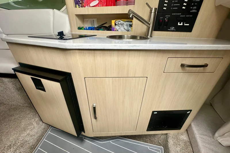 Slide: The Image of 2025 Regal 26 XO boat kitchenette with sink, storage, and control panel. - 46