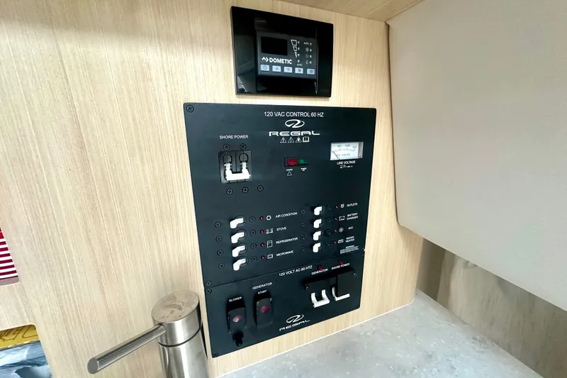 Slide: The Image of Control panel of 2025 Regal 26 XO boat, featuring switches and voltage display. - 49