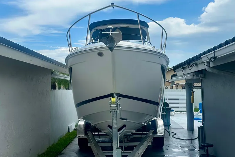 Slide: The Image of 2025 Regal 26 XO boat on trailer in driveway, under blue sky. - 6