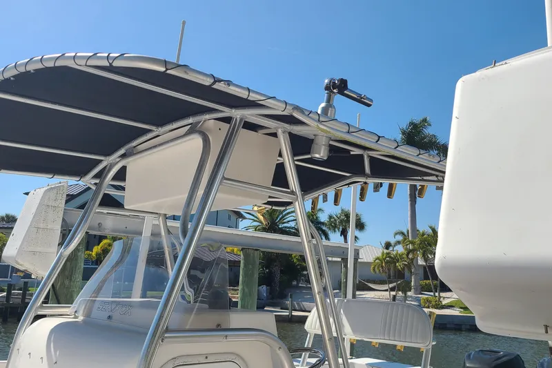 Slide: The Image of 2006 Sea Fox 287 Center Console boat with T-top and rod holders, docked under clear sky. - 18